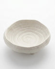 White ceramic bowl with spiral design on a white background