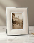 white luxury picture frame photograph of a city street scene on a marble surface with a neutral background