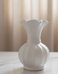 White ceramic vase on a light surface with a neutral background