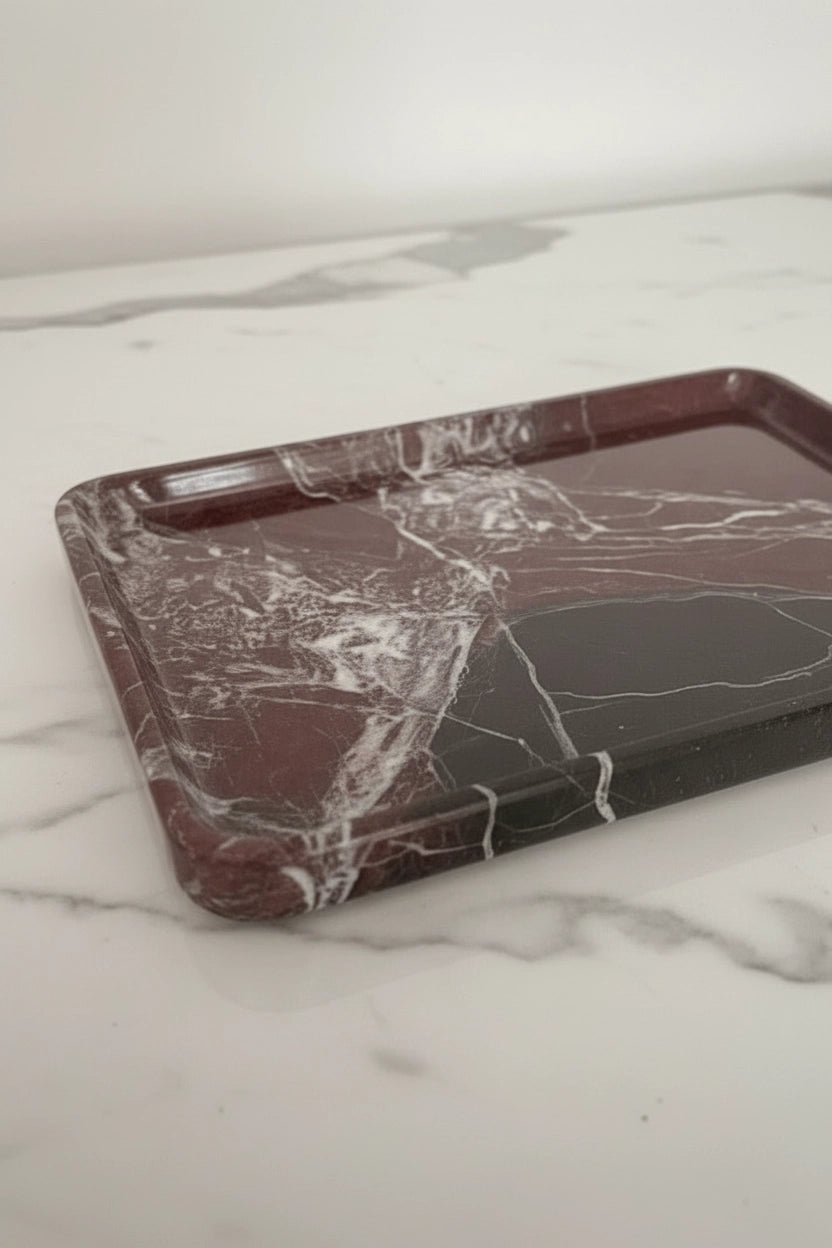 close up of a red marble tray on a plain background 