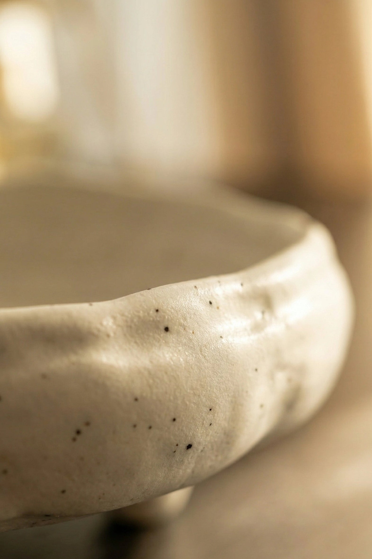 Close-up of a textured ceramic bowl with a blurred background