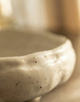 Close-up of a textured ceramic bowl with a blurred background