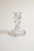 A clear glass candlestick holder with a flared base and a ribbed stem, photographed on a plain light background.