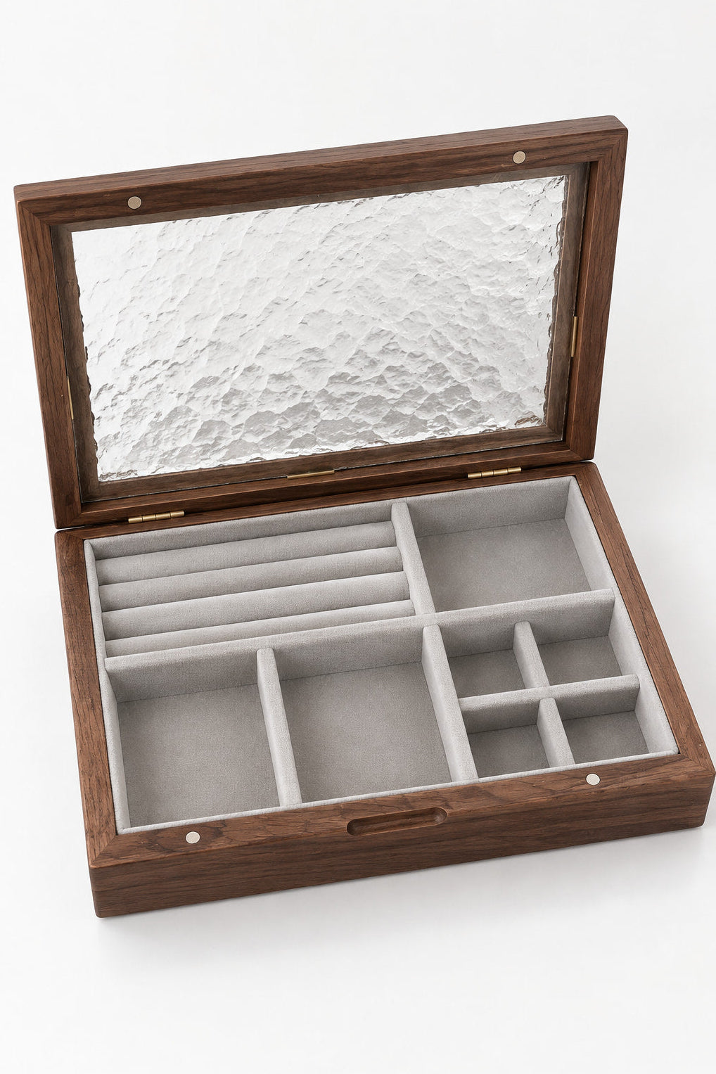 An open wooden jewelry organizer box with a textured glass lid, featuring multiple interior compartments lined in light gray velvet.