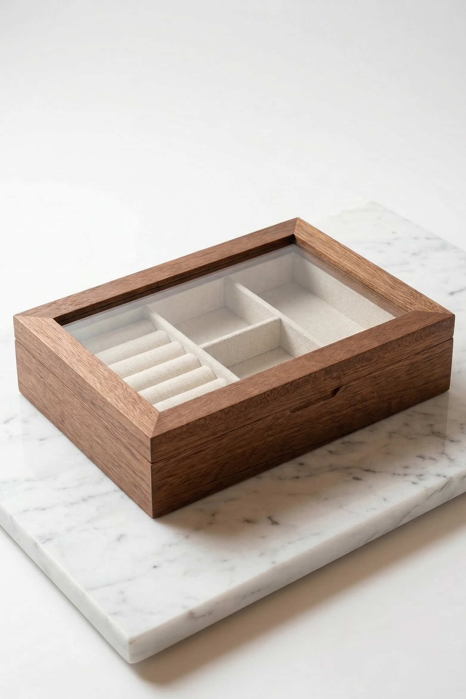 Wooden jewelry box with glass lid on a marble surface