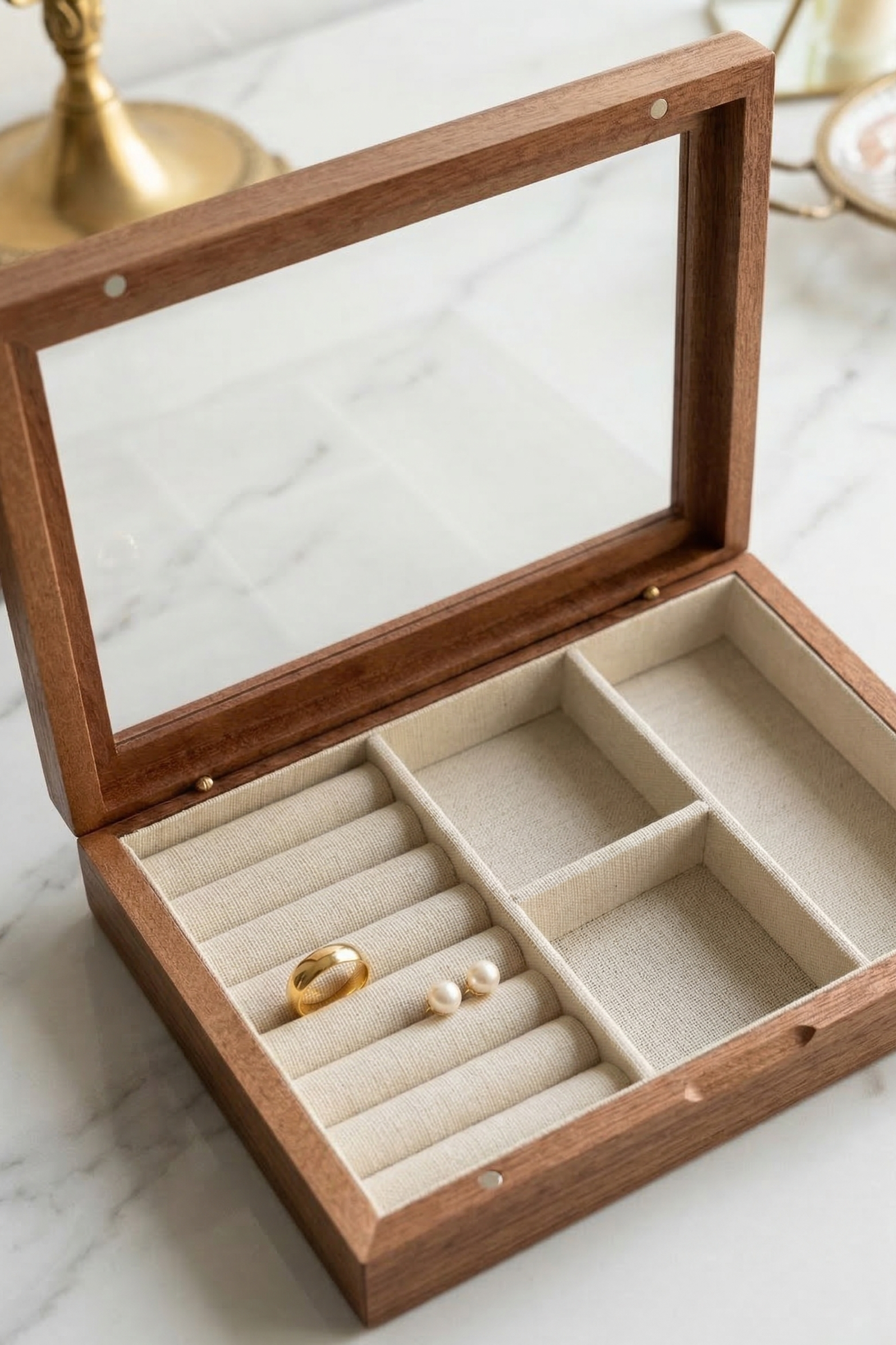 Wooden jewelry box with glass top on a marble surface