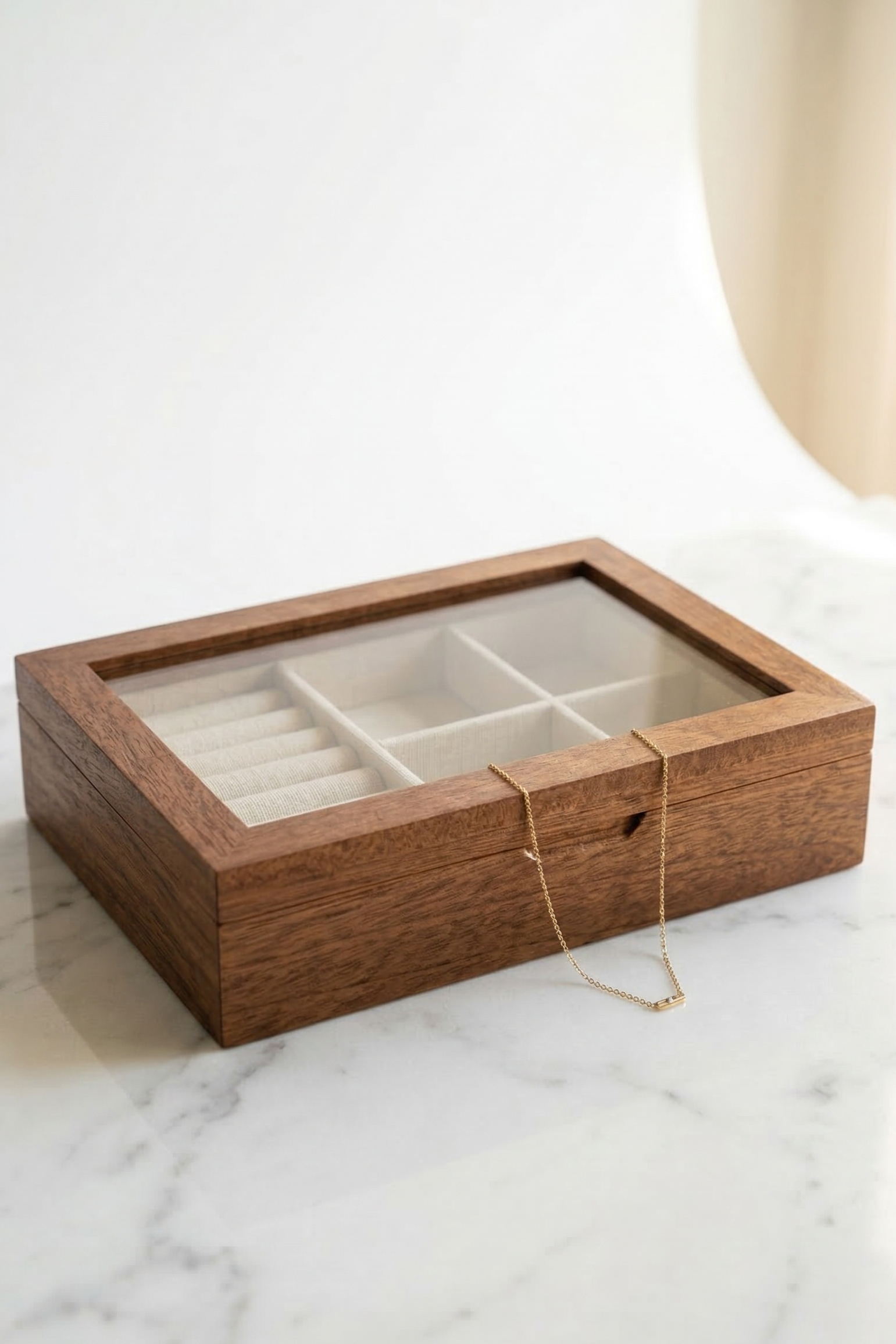 Wooden jewelry box with a necklace on a marble surface