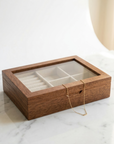 Wooden jewelry box with a necklace on a marble surface