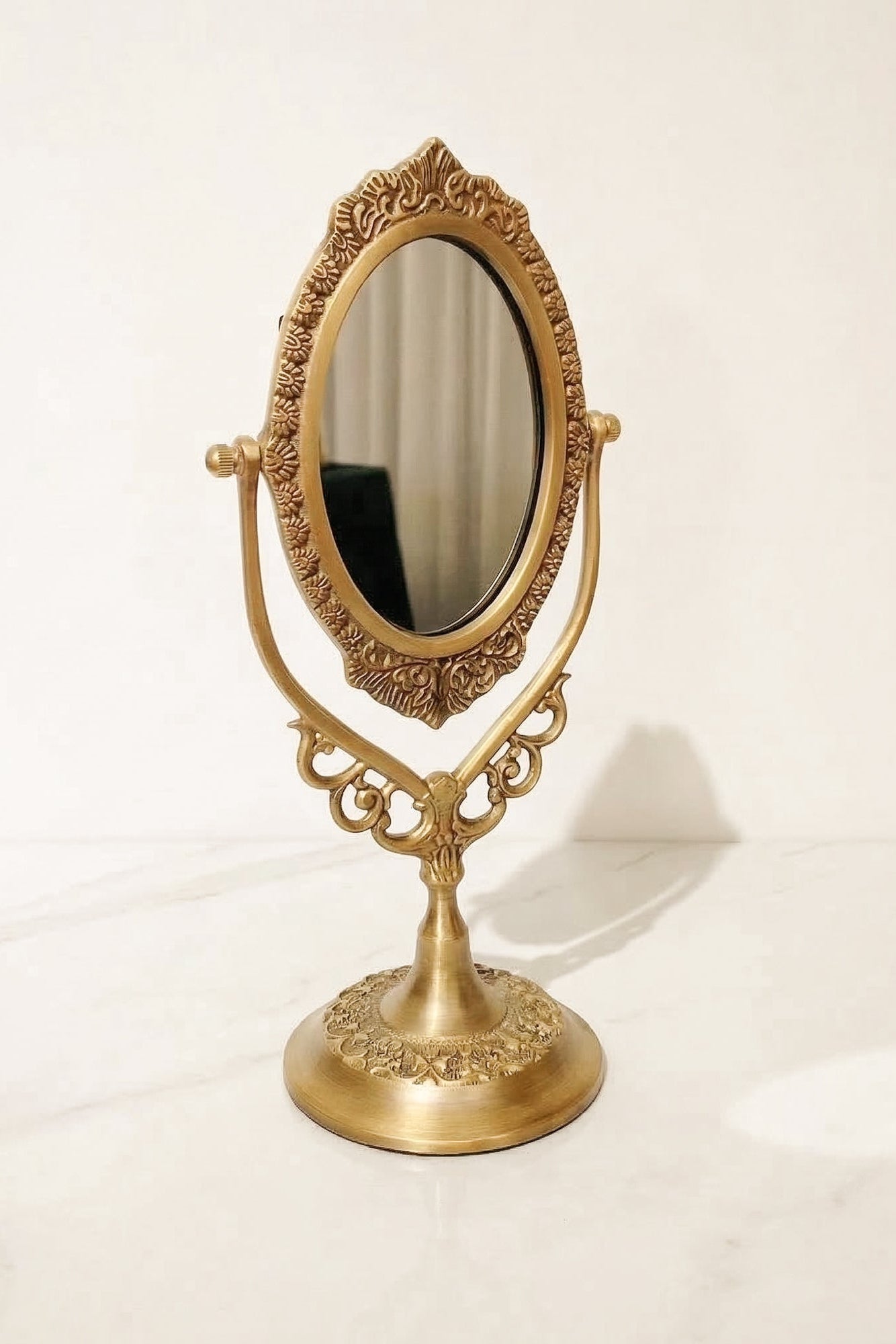 Decorative brass vanity mirror on a white background