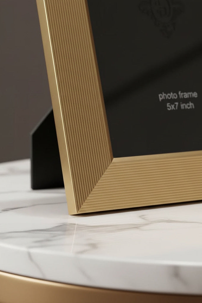 Gold photo frame on a marble surface with text indicating size.