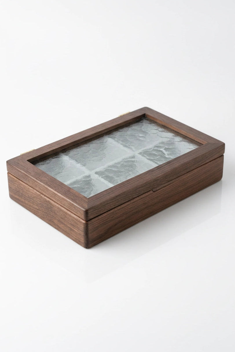 A rectangular wooden jewellery box with a hinged lid and a clear glass top divided into multiple compartments, shown on a clean white background.