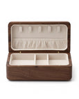 A rectangular wooden jewelry box shown open, featuring a dark brown wood exterior and a cream-colored interior with five hanging loops on the lid and three compartments in the base.