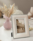 Decorative setting with a luxury framed , pink glass vase with dried flowers.