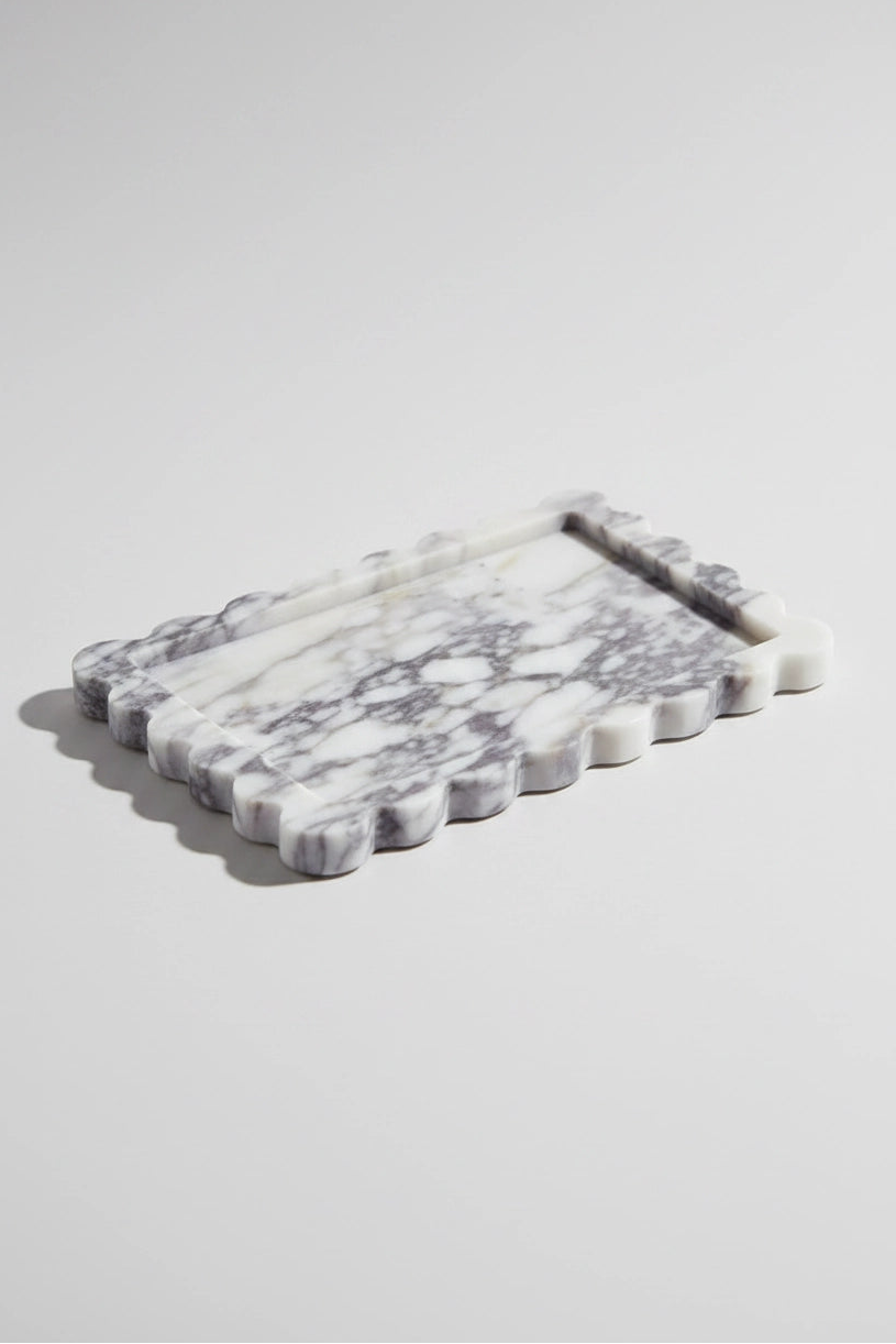 A rectangular white marble serving tray with a scalloped edge and a recessed center, shown on a light gray background.