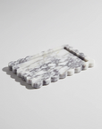 A rectangular white marble serving tray with a scalloped edge and a recessed center, shown on a light gray background.
