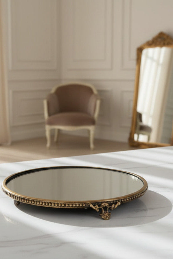 Decorative  brass round mirror tray with  frame on a table in a room with a chair and mirror.