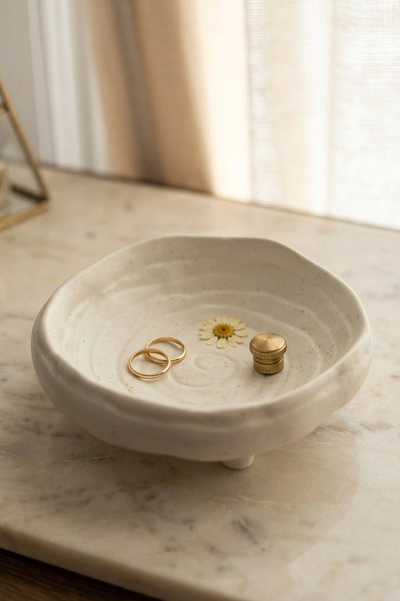 White ceramic dish with rings on a marble surface