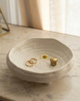 White ceramic dish with rings on a marble surface