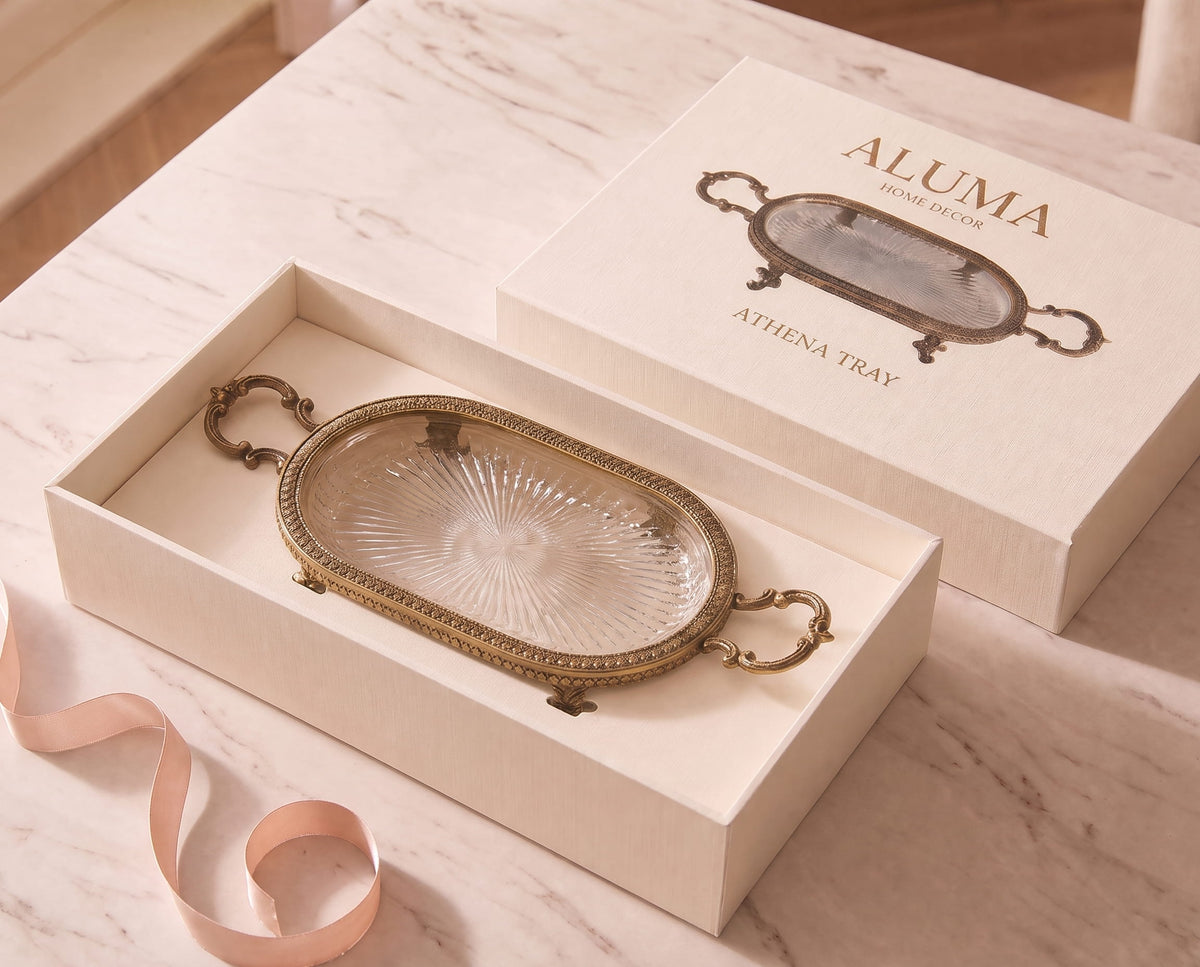 The Athena Tray resting inside its open gift box and pink ribbon on a marble ttable 