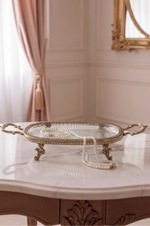 The Athena Tray in antique brass with a fluted glass base, on a plain background.