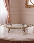 The Athena Tray in antique brass with a fluted glass base, on a plain background.