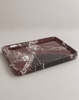 A rectangular marble serving tray with a deep rim, featuring a dark reddish-brown and black marble pattern with white veining, set against a neutral light gray background.
