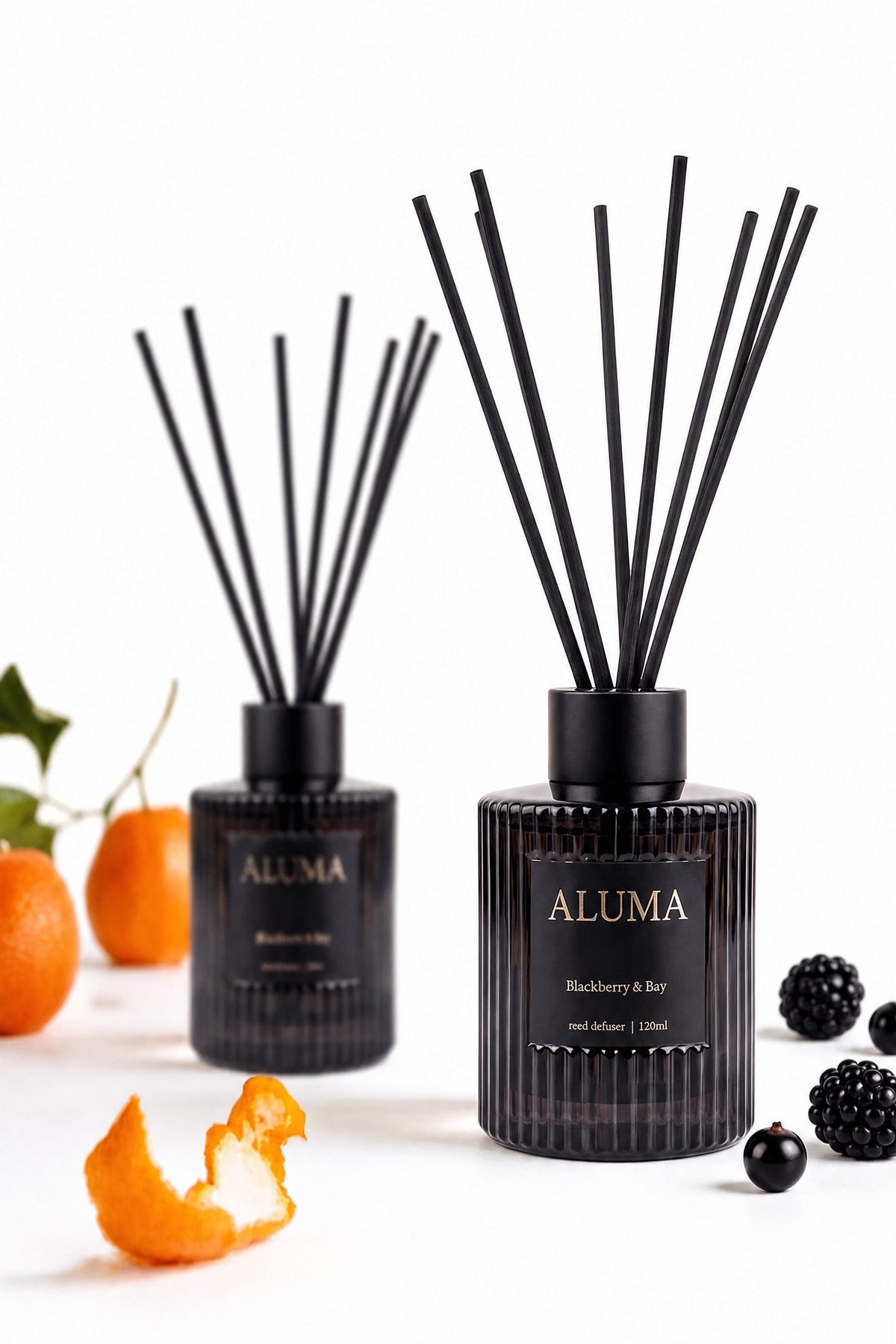 Aluma Blackberry & Bay reed diffuser 110ml — dark glass bottle with reeds, styled with orange, blackcurrant and blackberry
