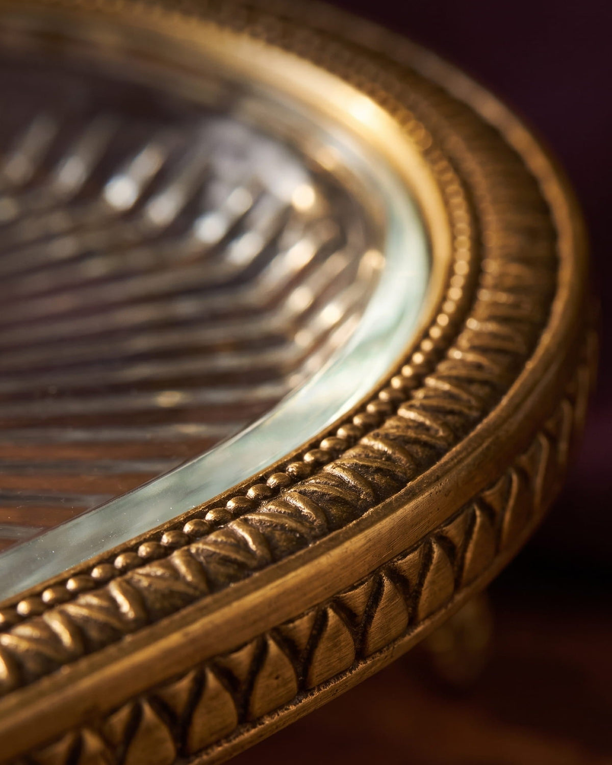 Close-up of the hand-finished brass rim and glass surface of the Athena Tray