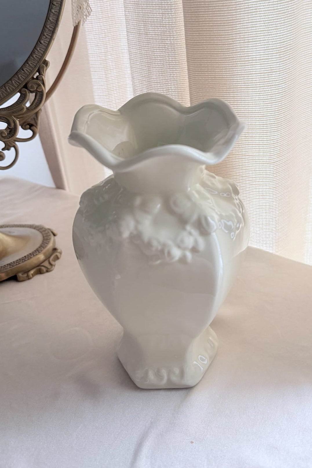 White decorative vase on a surface with a blurred background
