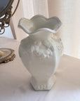 White decorative vase on a surface with a blurred background