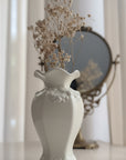 White decorative vase with floral patterns on a light background